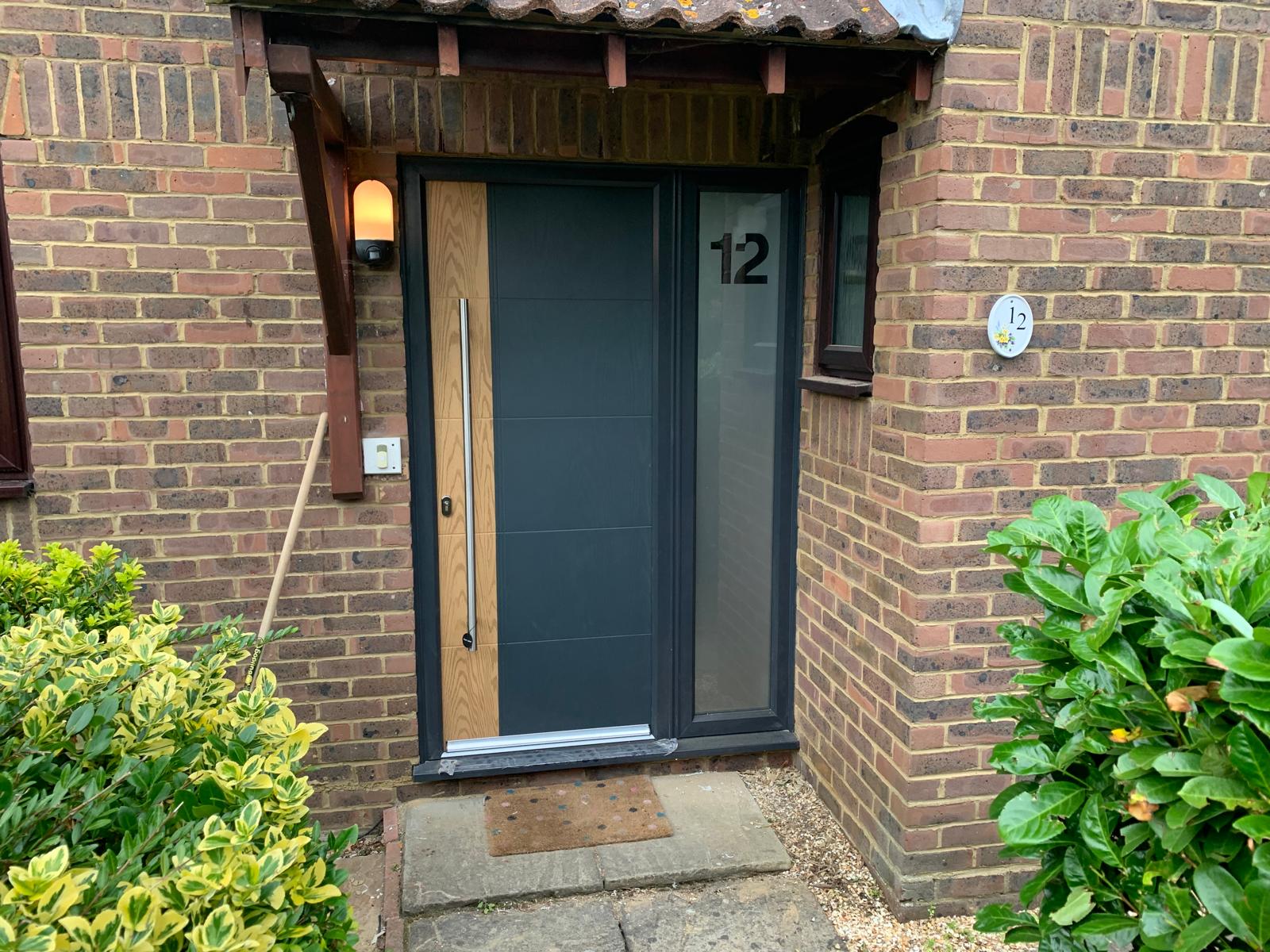 Contemporary grey and oak front door with glazed side panel fitted near Cambridge