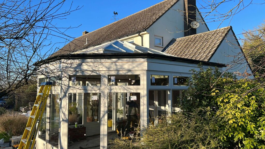 Grey conservatory with glazed roof on a rendered family home