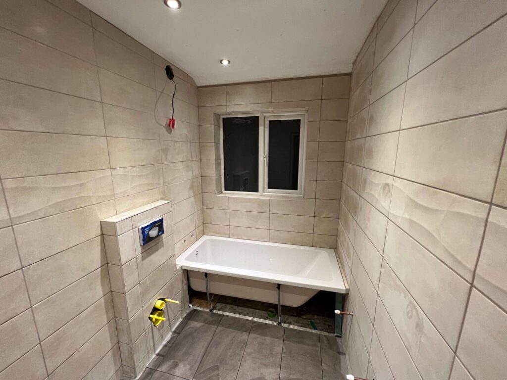 Bathroom refit with large-format wall tiles and a new bath