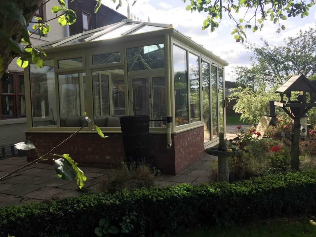 Conservatory on a dwarf brick wall in a mature garden