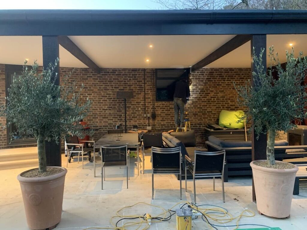Covered outdoor living area with downlights and olive trees