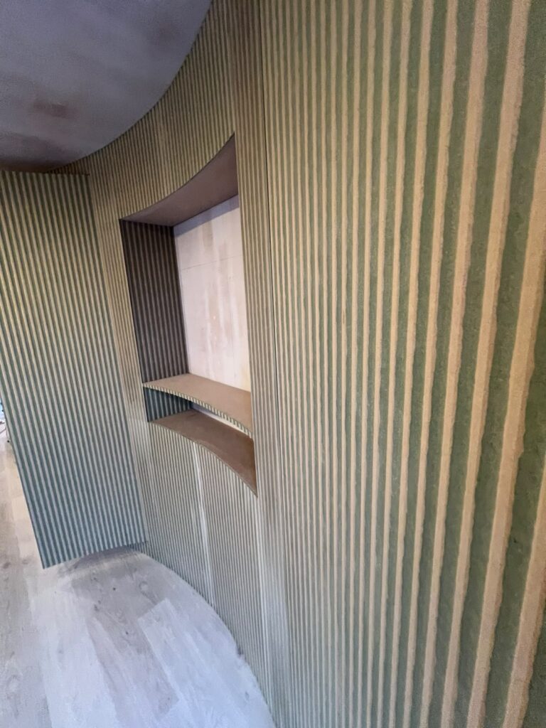 Close-up of curved fluted panelling with curved niche shelves