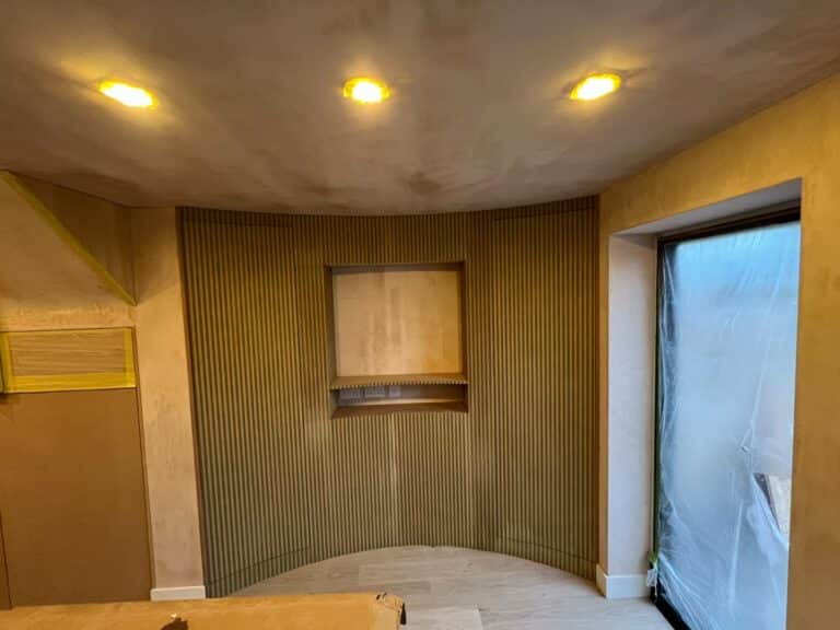 Curved fluted wall panelling with a recessed niche and hidden doors