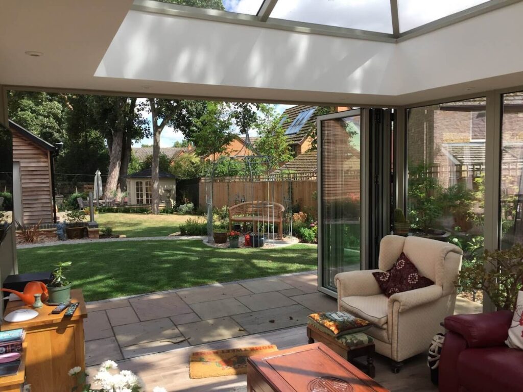 Glazed garden room with sofas looking out onto the lawn