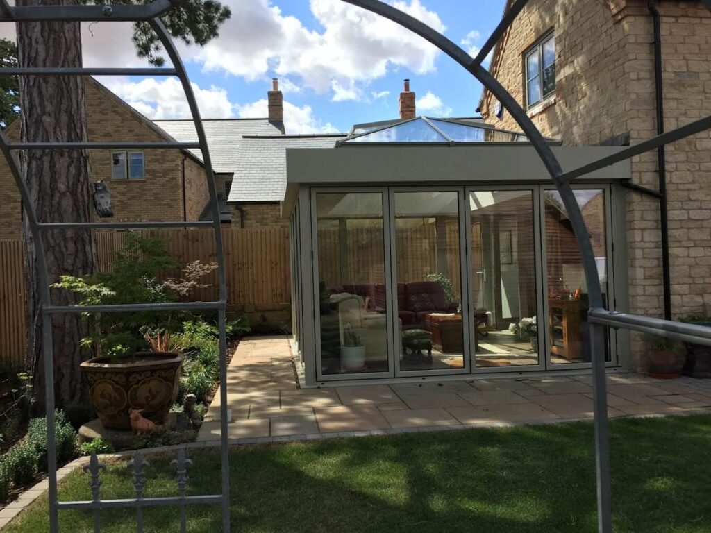 Grey conservatory seen through a garden arch
