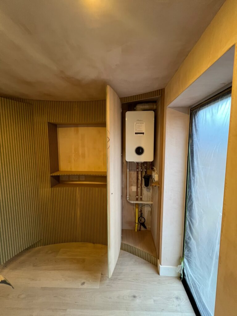 Flush door in a fluted wall opening to a hidden boiler cupboard