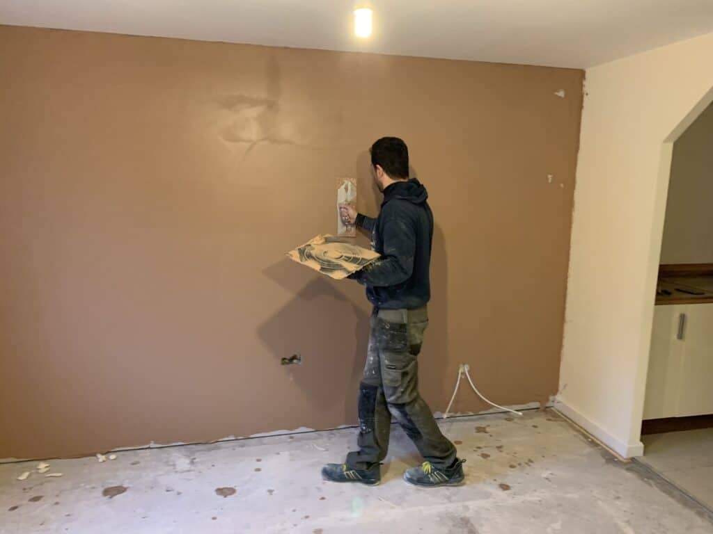 Plasterer skimming a wall during a renovation