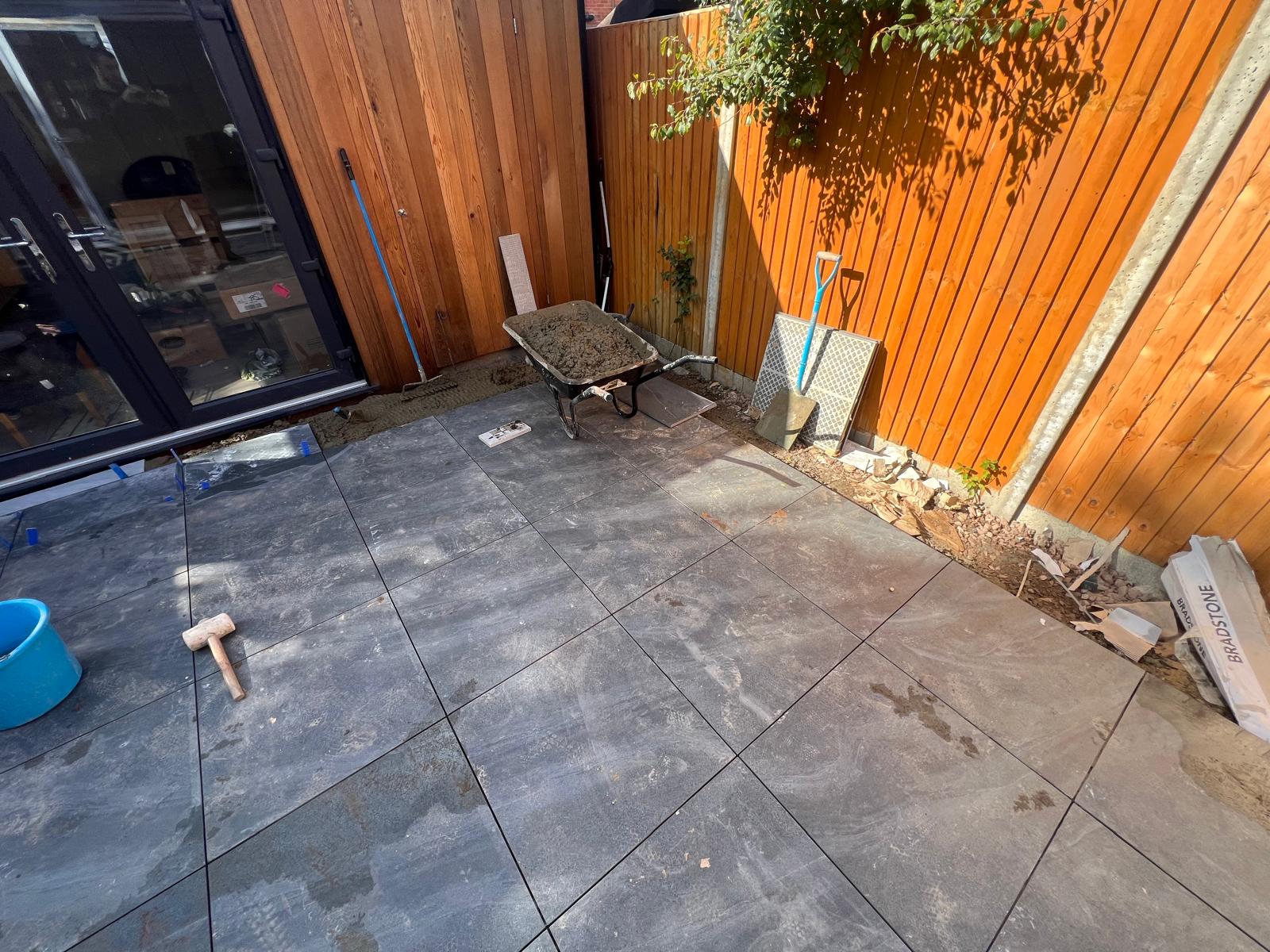 Porcelain paving being laid beside timber fencing