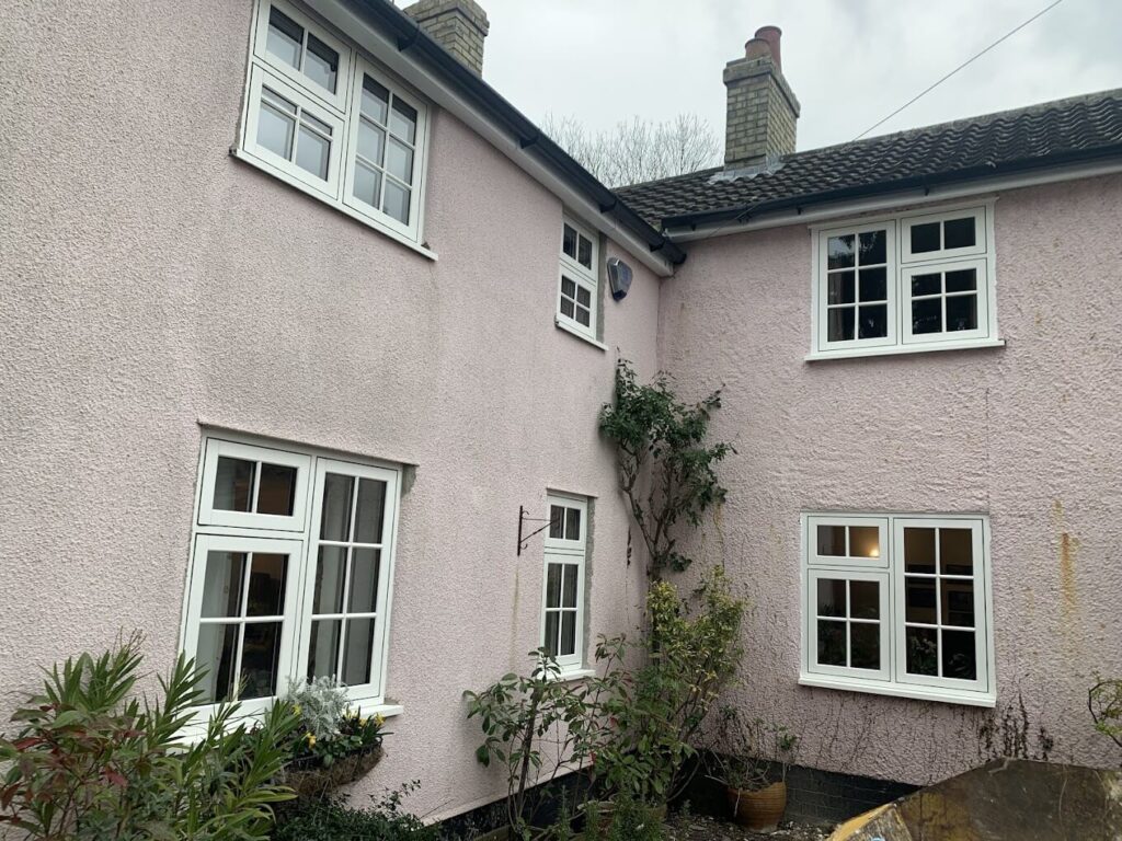 Exterior of a rendered period home with white windows