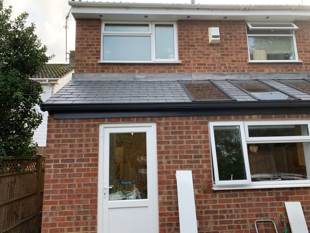 Small brick extension with a flat roof and white door